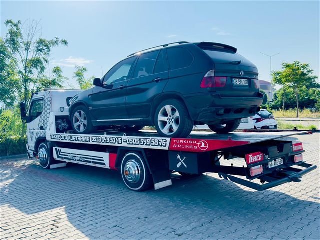 Gündüz çekim: Tekçe oto kurtarma platform çekicisi üzerinde siyah SUV