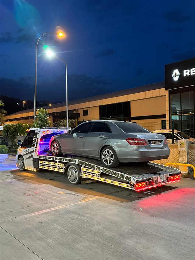 Akşam, bayi önünde çekiciye yüklenmiş sedan