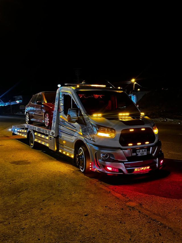Gece, ışıkları açık Tekçe çekici yüklü araçla